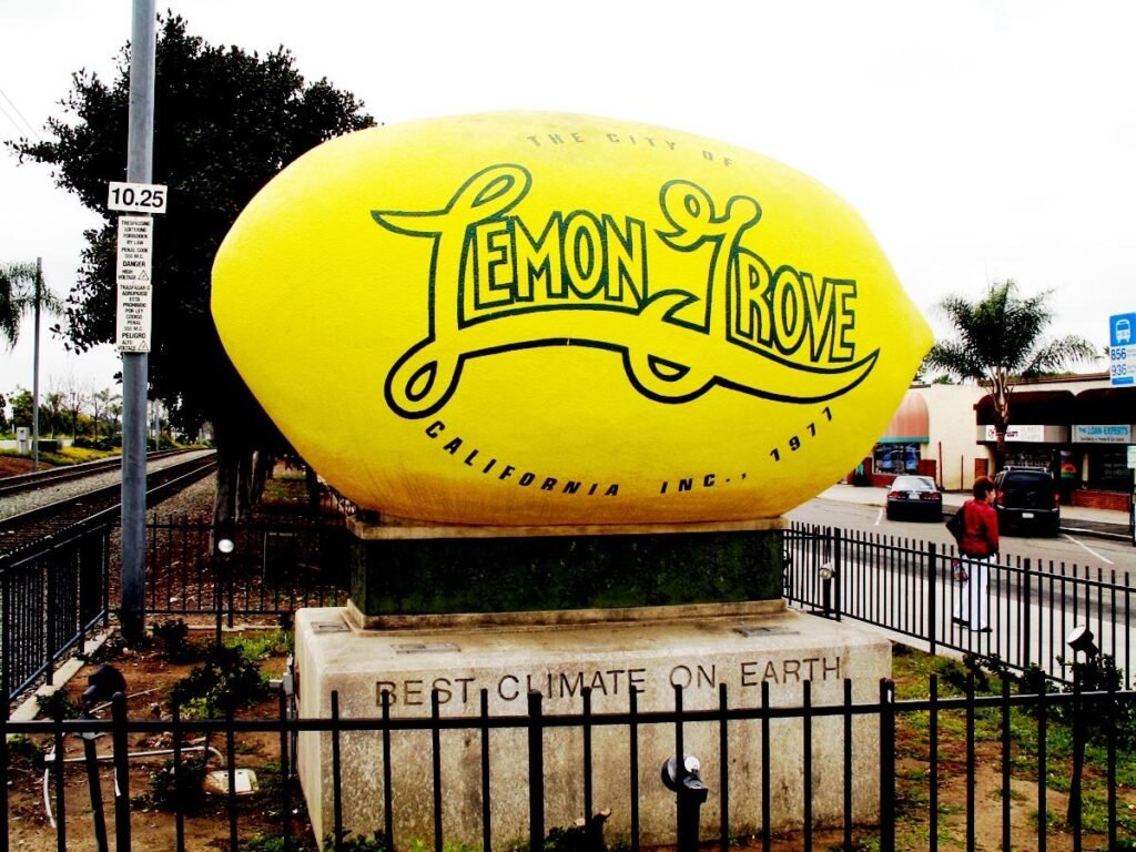 Large lemon-shaped &ldquo;Lemon Grove&rdquo; landmark sign beside railroad tracks in Lemon Grove, California.