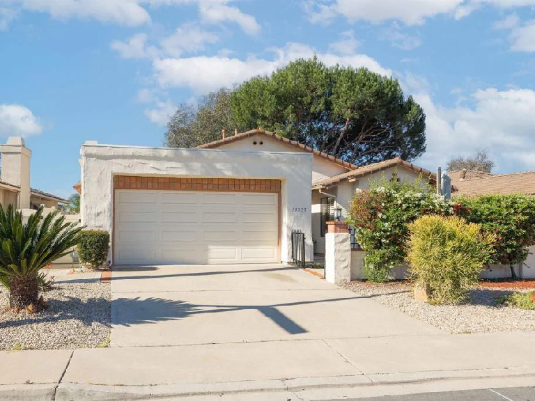 Modern home exterior with landscaped front yard and driveway showcasing residential property
